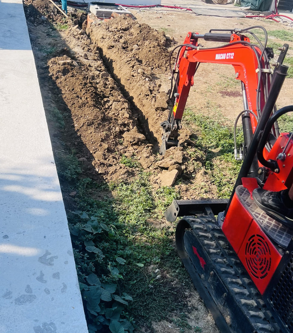 Mașină de săpat șanțuri înguste lângă gard