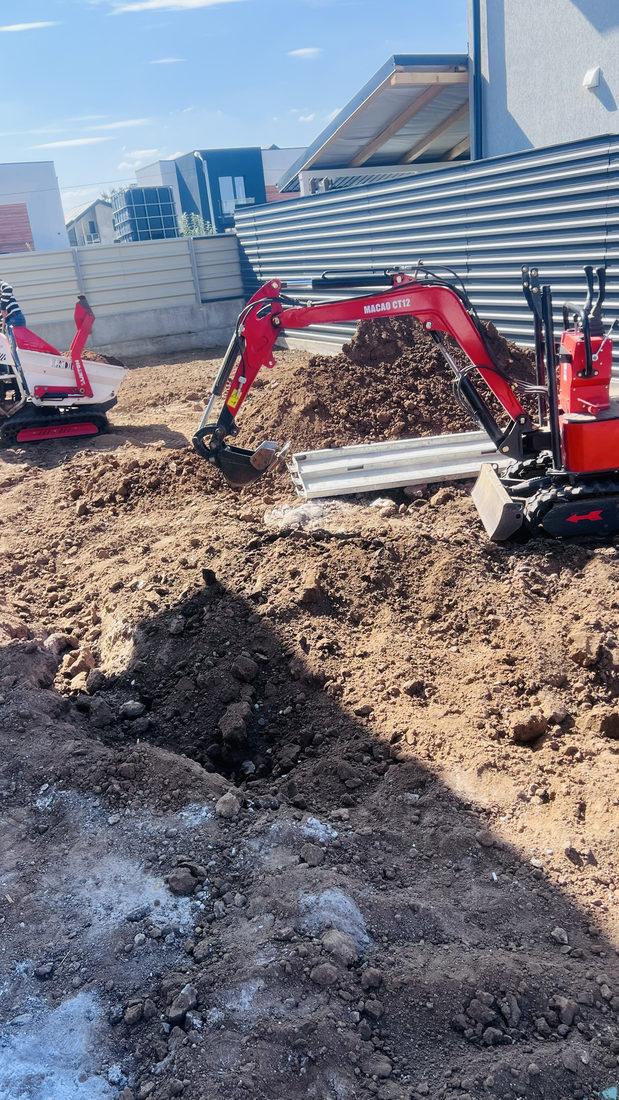 Excavator săpând șanț pentru țeava de irigații